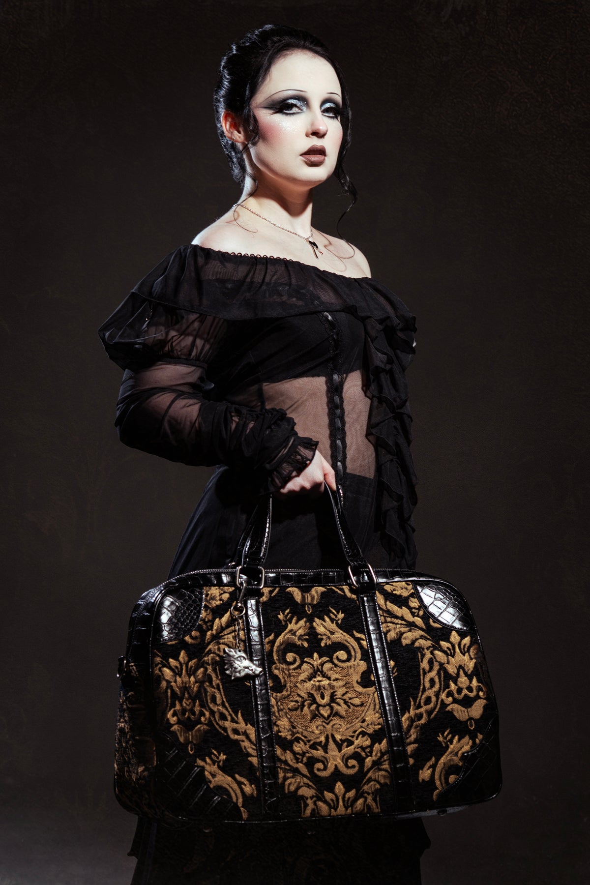 Victorian Psycho collaboration - Model is holding a large carpet bag in her right arm