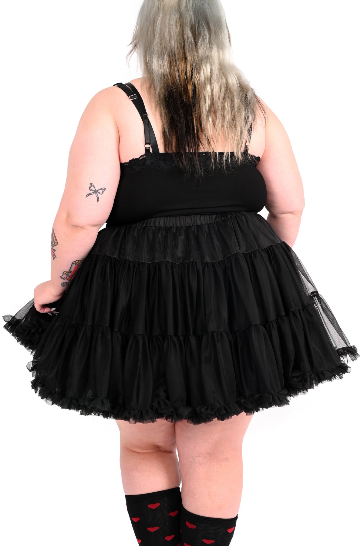 Person wearing a black layered petticoat on a white background