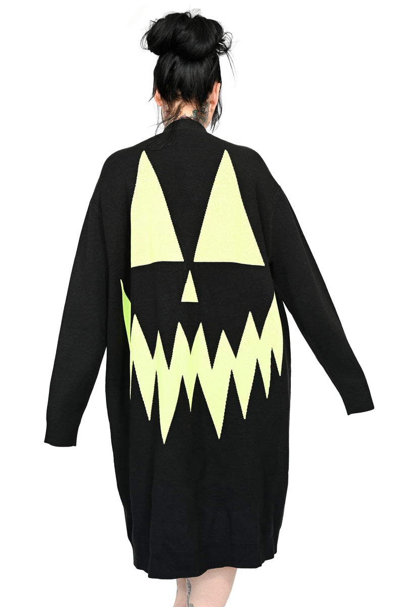 black sweater duster with green glow in the dark jackolantern face on back