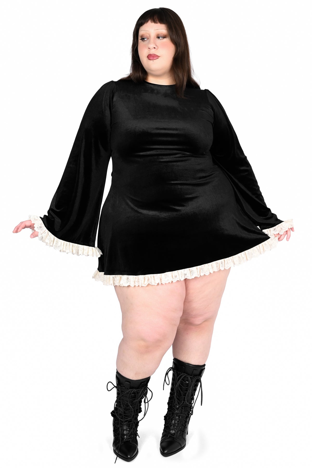plus size model in a blacl velvet dress with white lace trim 