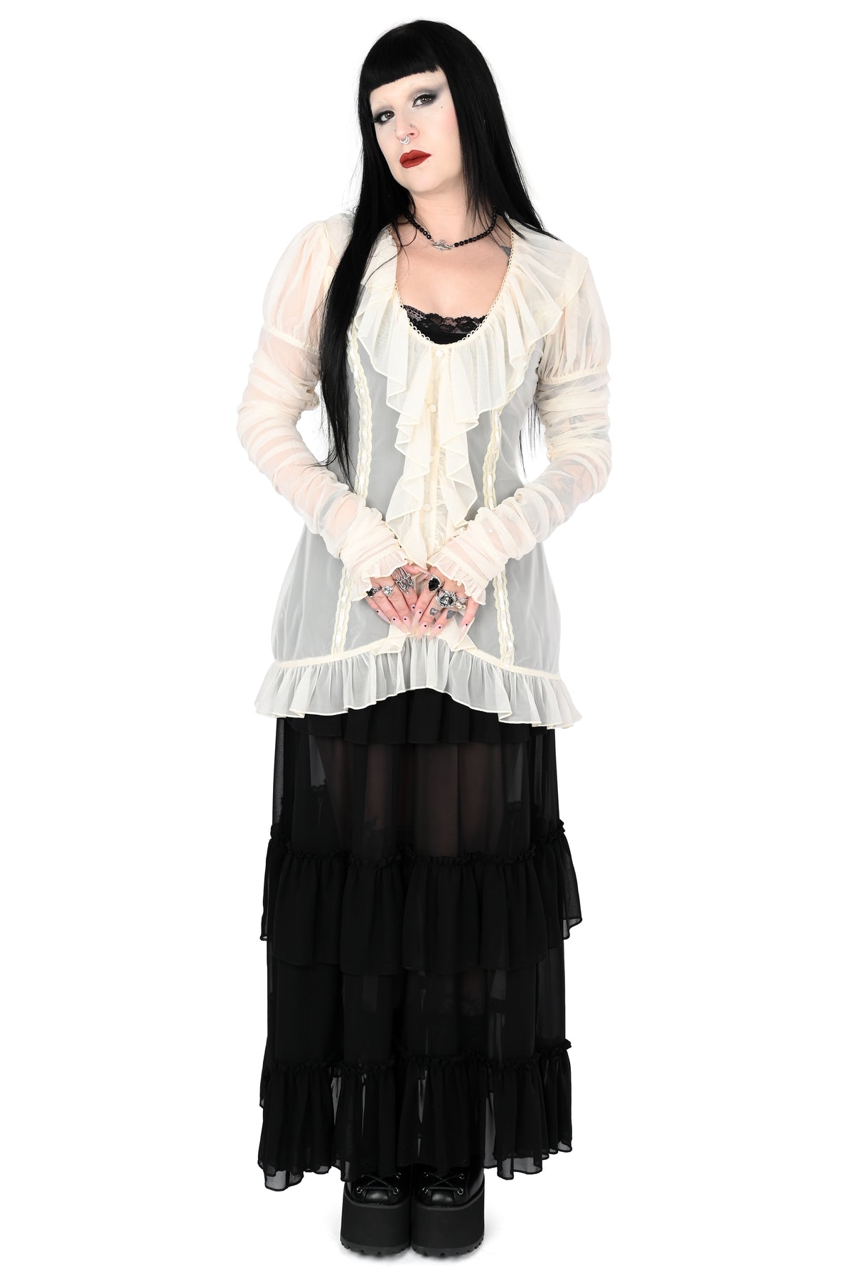 model wearing a cream sheer ruffle top with satin lace details in size xs