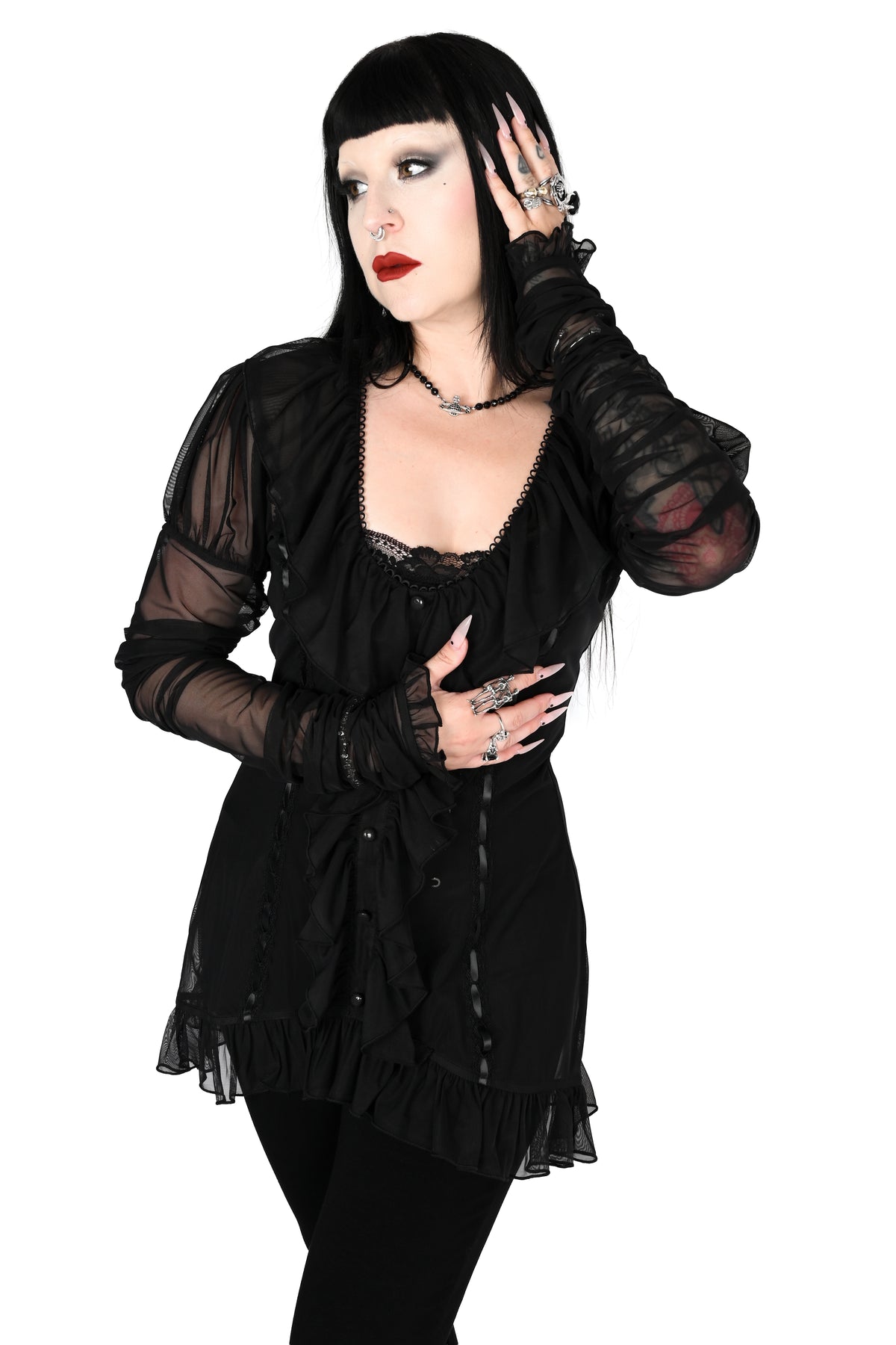 model wearing a black sheer ruffle top with satin lace details in size xs