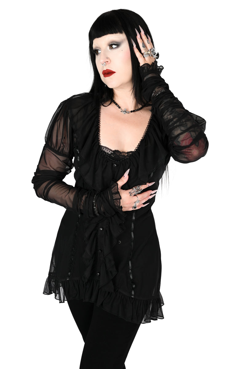 model wearing a black sheer ruffle top with satin lace details in size xs