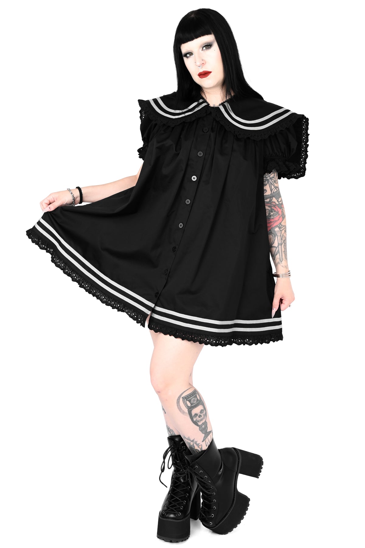 model wearing a black sailor dress with off-white stripe detailing and lace trim in size xs, the model is holding one side of the dress out