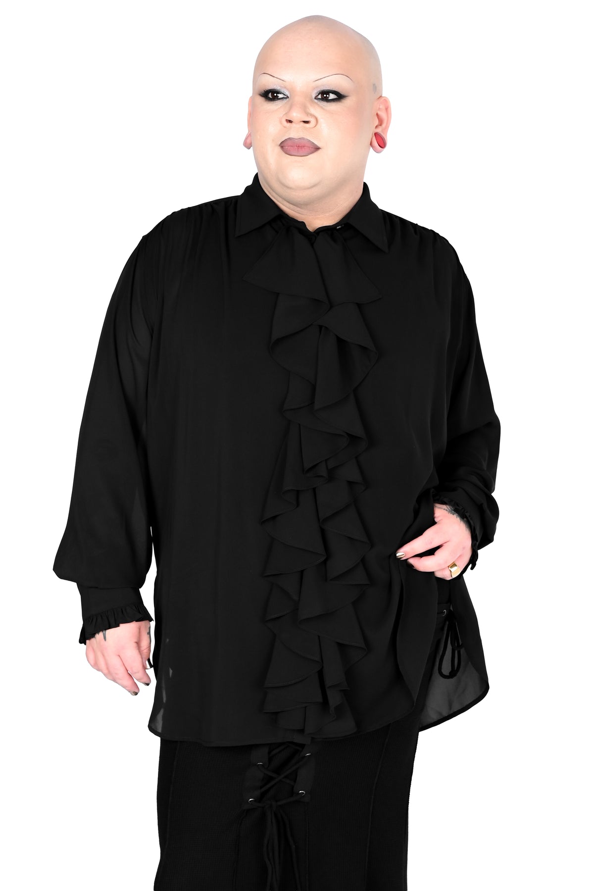 A model wearing a black long-sleeve blouse with a dramatic cascading ruffle design down the front in size 2xl and black pants, photographed against a solid white background.