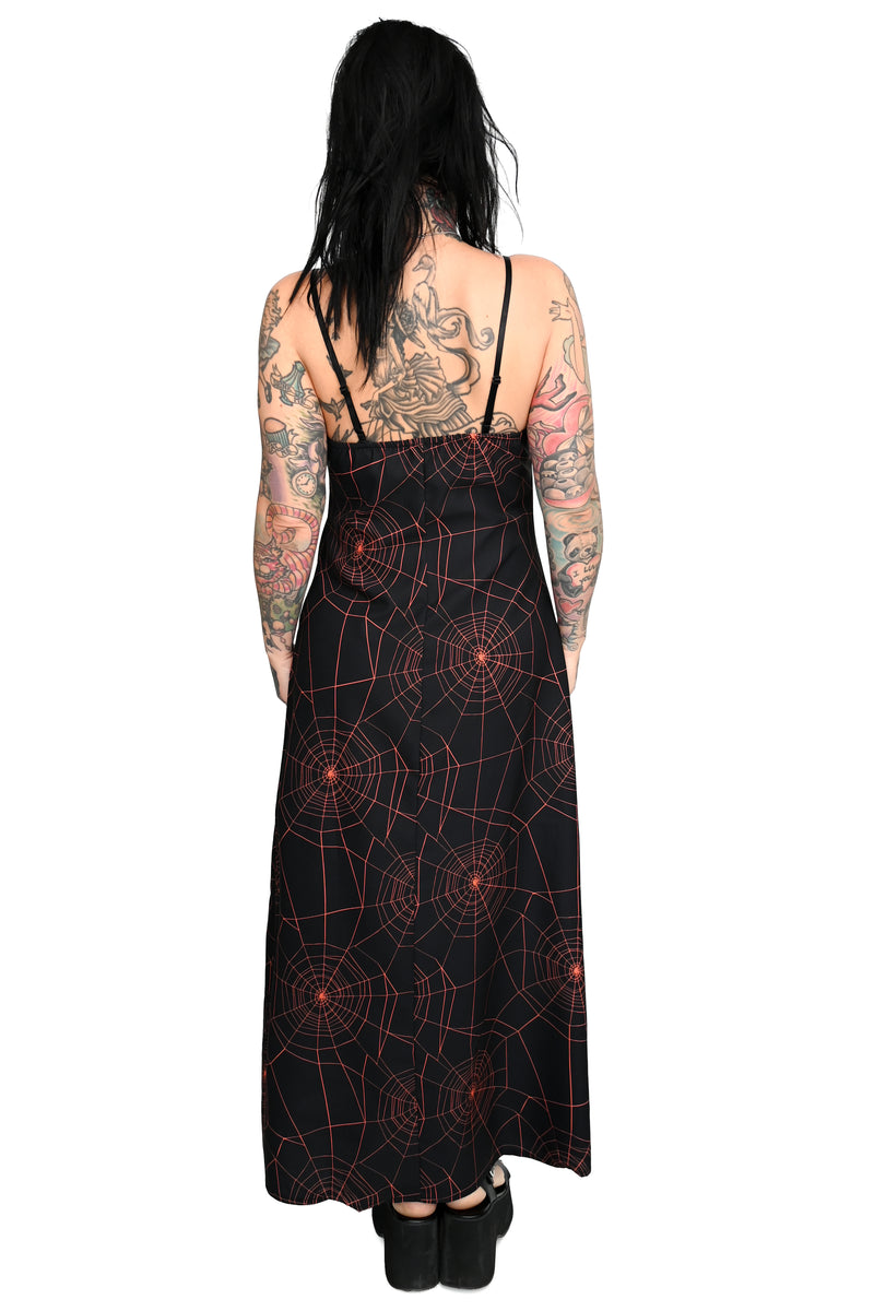 black maxi slip dress with all over orange spiderweb print with side slit