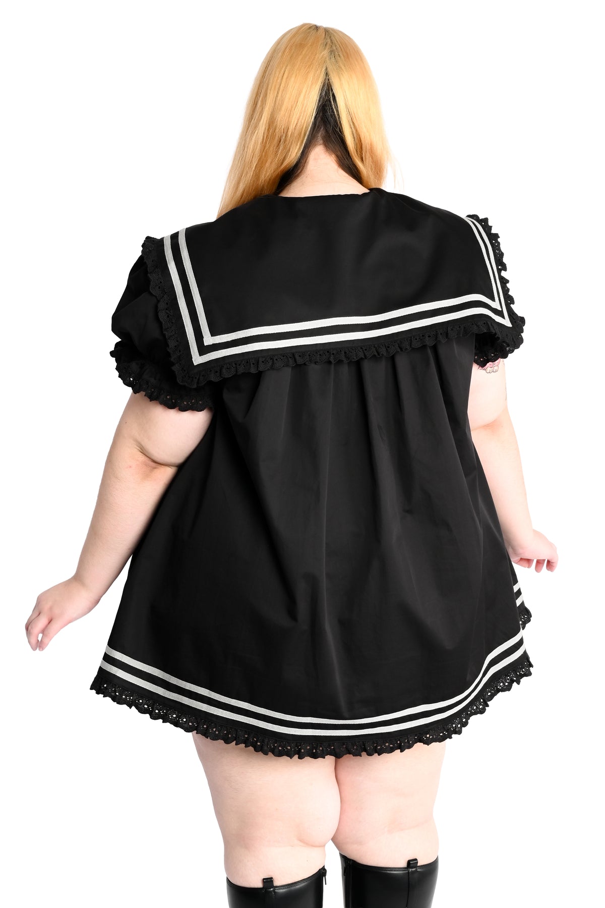 back view of a model wearing a black sailor dress with off-white stripe detailing and lace trim in size 2xl