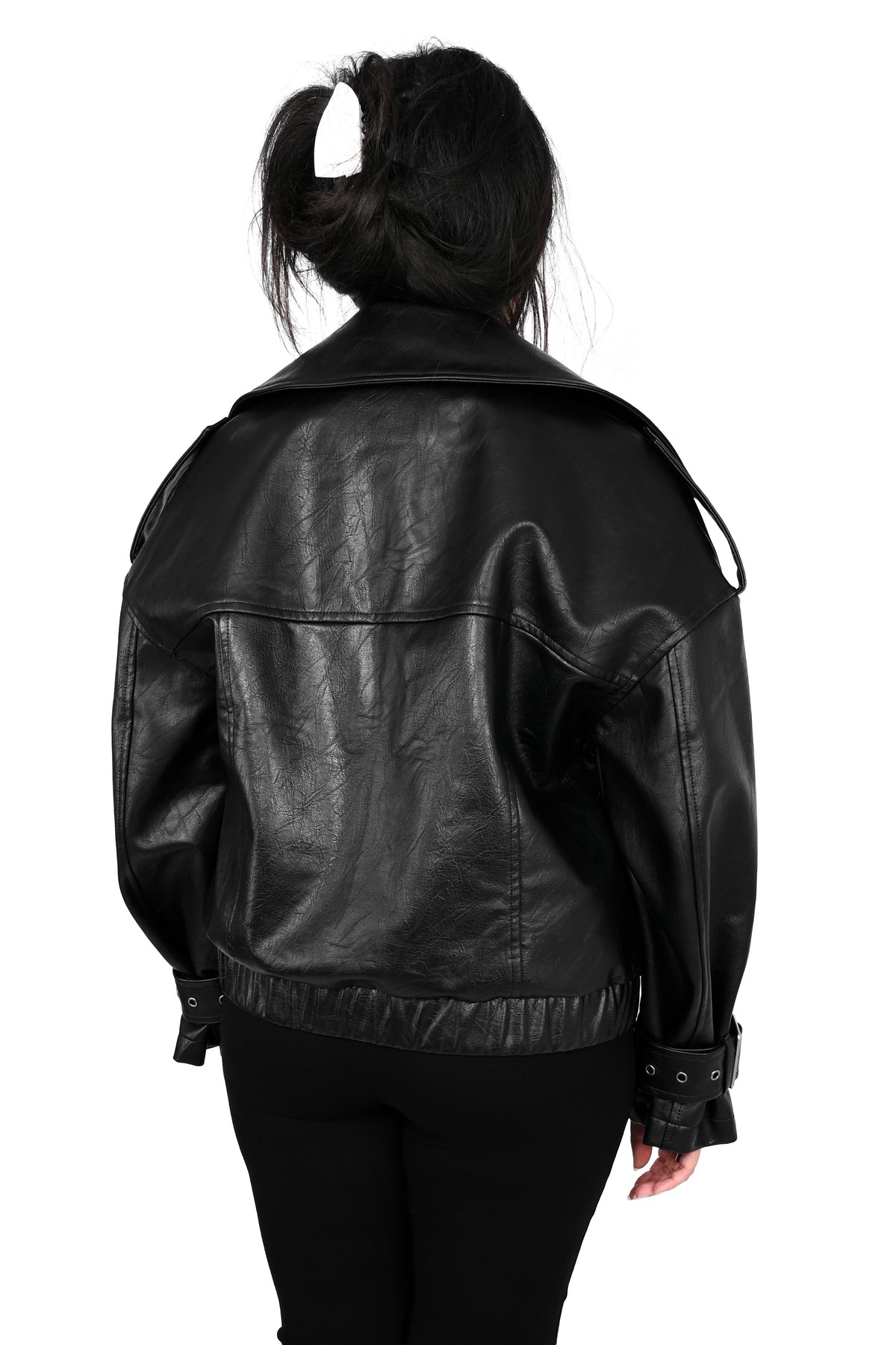 A person viewed from the back wearing a black leather jacket and black pants against a plain white background.