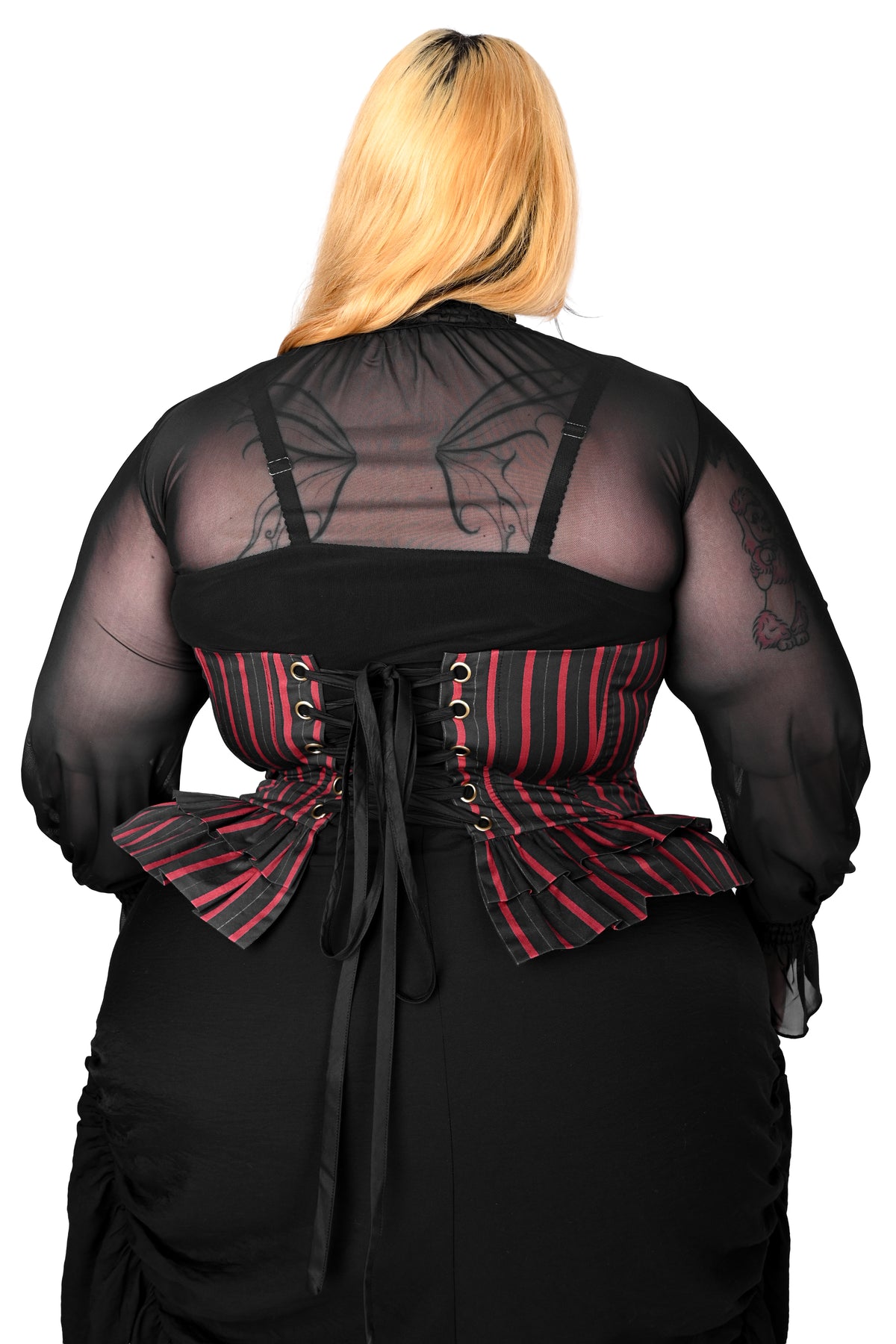 A person shown from the back wearing a black sheer long-sleeve top with bat-wing back detailing, a black corset-style waist with red and black vertical stripes, and a black skirt against a plain white background.