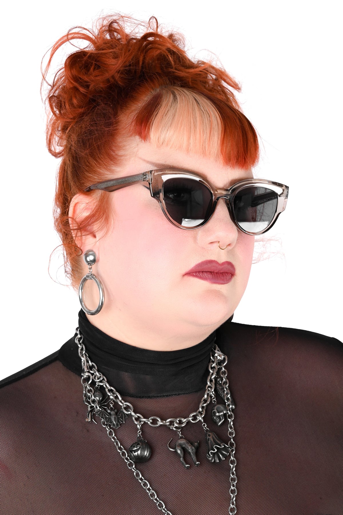 3/4 view of a model wearing smokey grey/clear frame sunglasses with black lenses shot on a white background