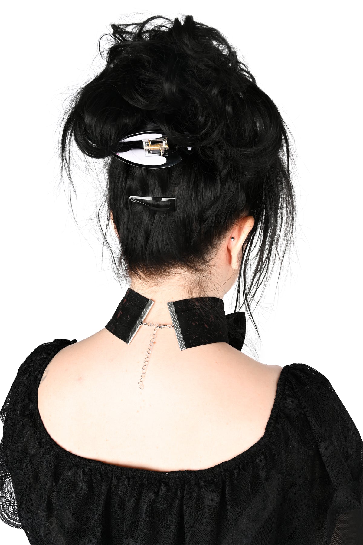 Back view of a person with messy black hair wearing a black choker collar showing off the lobster clasp closure against a plain white background.