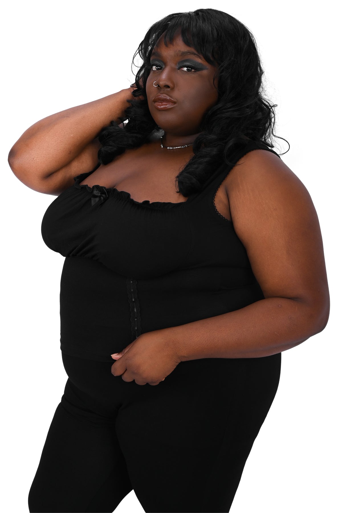 Woman wearing a black sleeveless top and pants on a white background