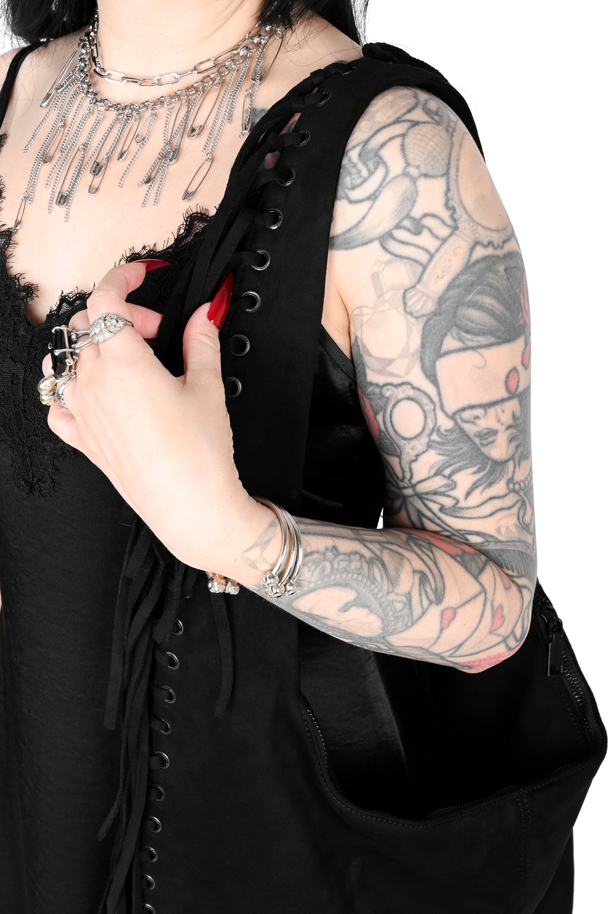 Black faux suede shoulder bag with fringe trim all around.