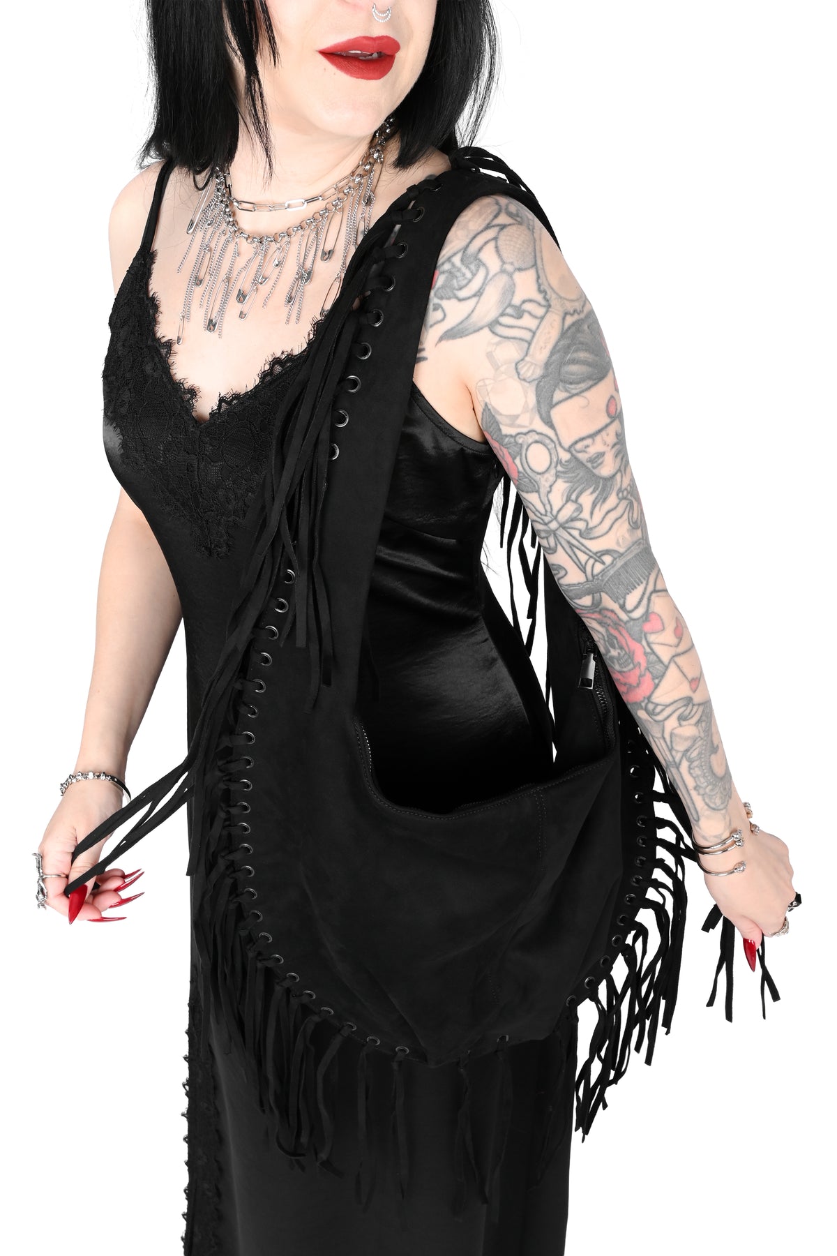 Black faux suede shoulder bag with fringe trim all around.