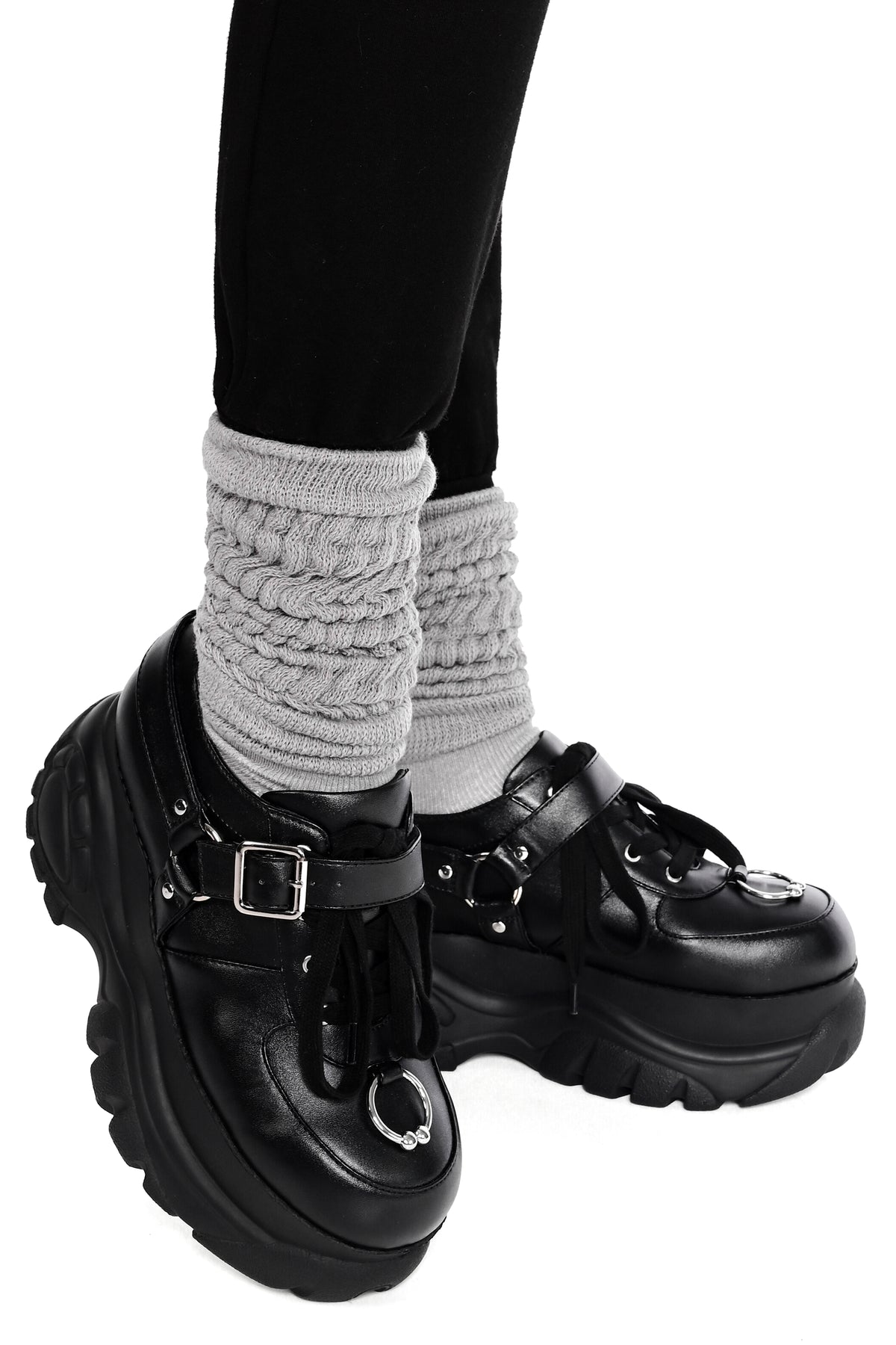 black platform sneakers with front horseshoe piercing detail and side buckle harness