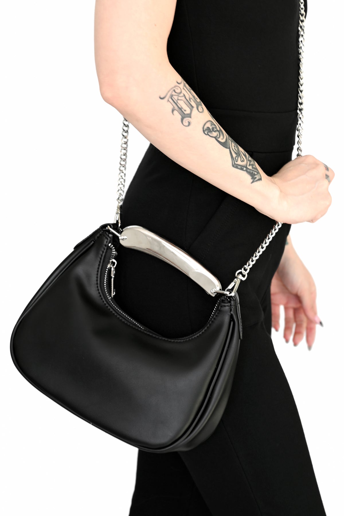 black faux leather purse with a chunky silver plated top handle and chain crossbody strap