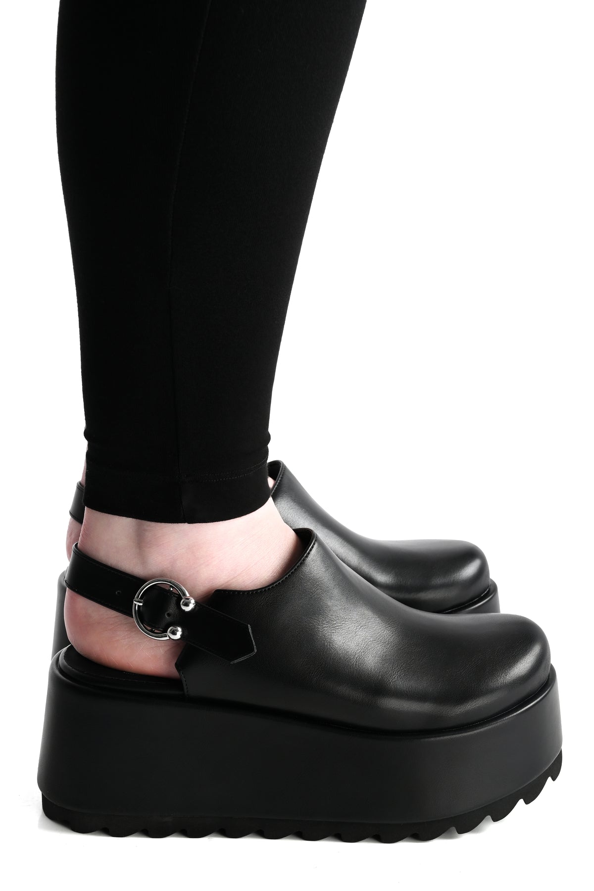black platform clogs with a horseshoe piercing buckle