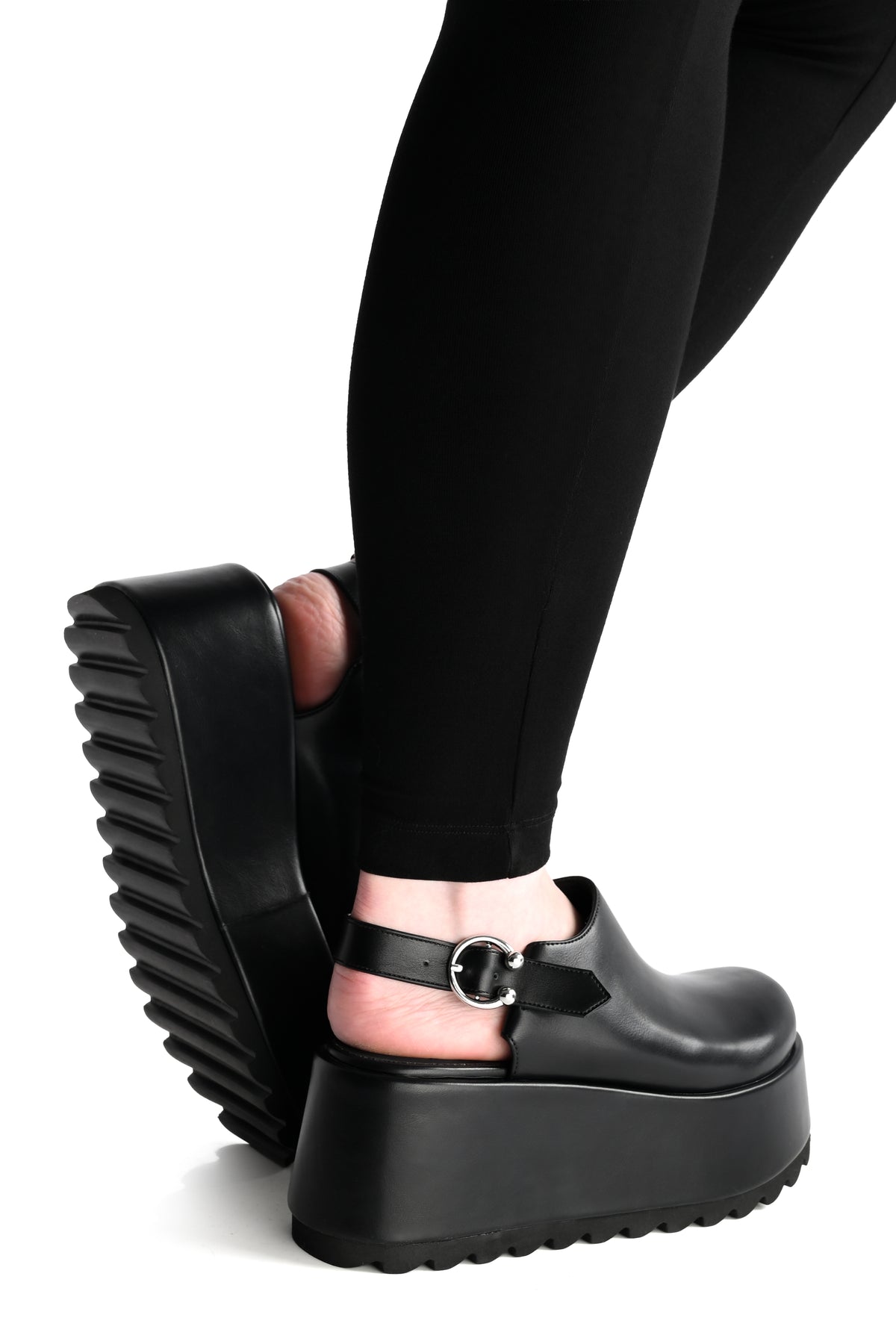 black platform clogs with a horseshoe piercing buckle