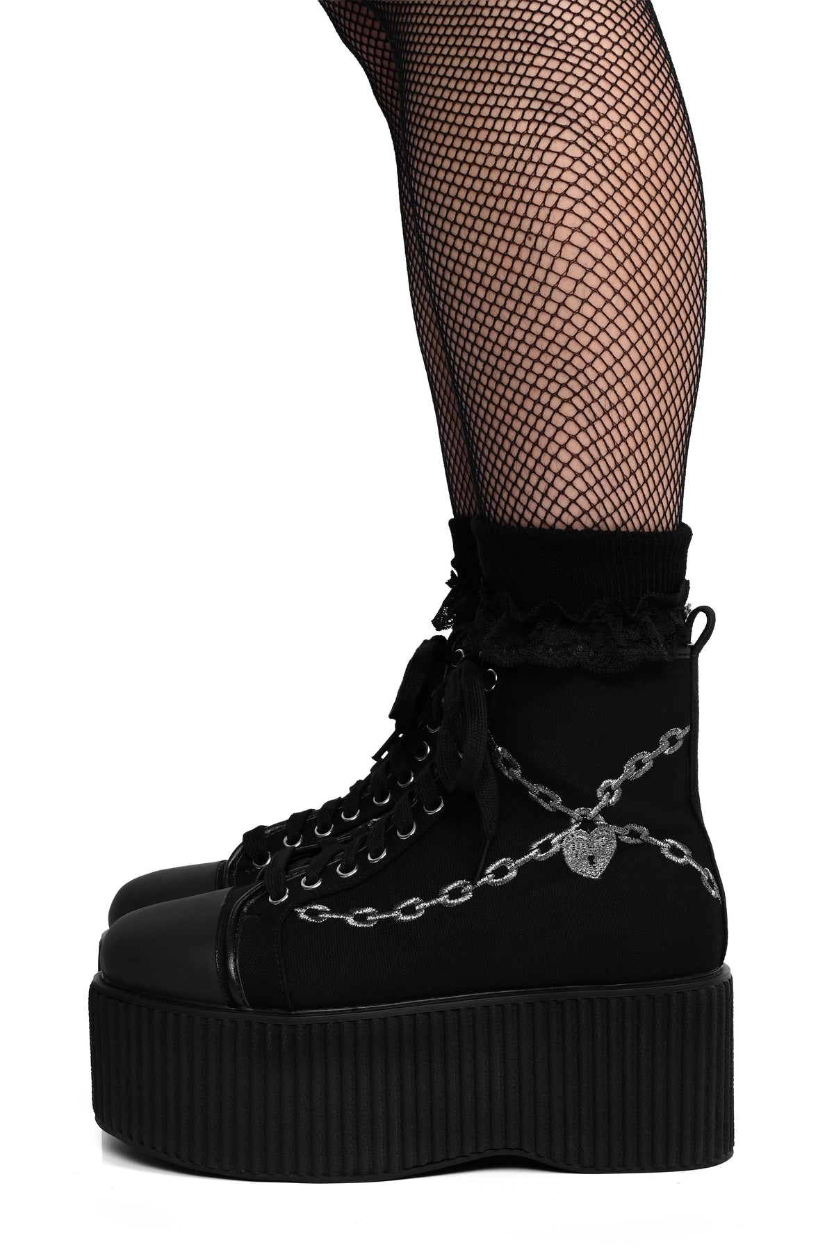 Black platform sneakers with silver embroidered chain and heart locket detail