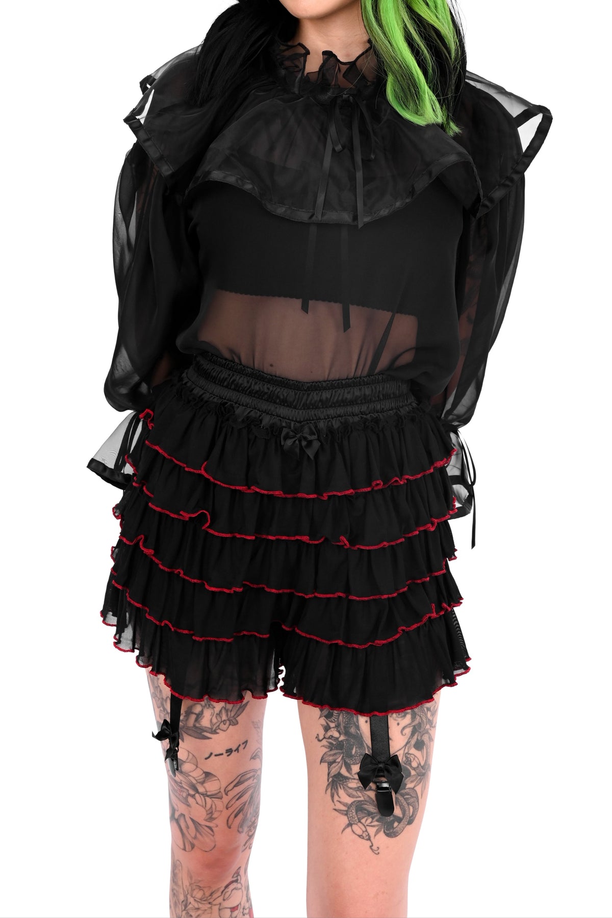 Person wearing a black outfit with ruffled details on a white background