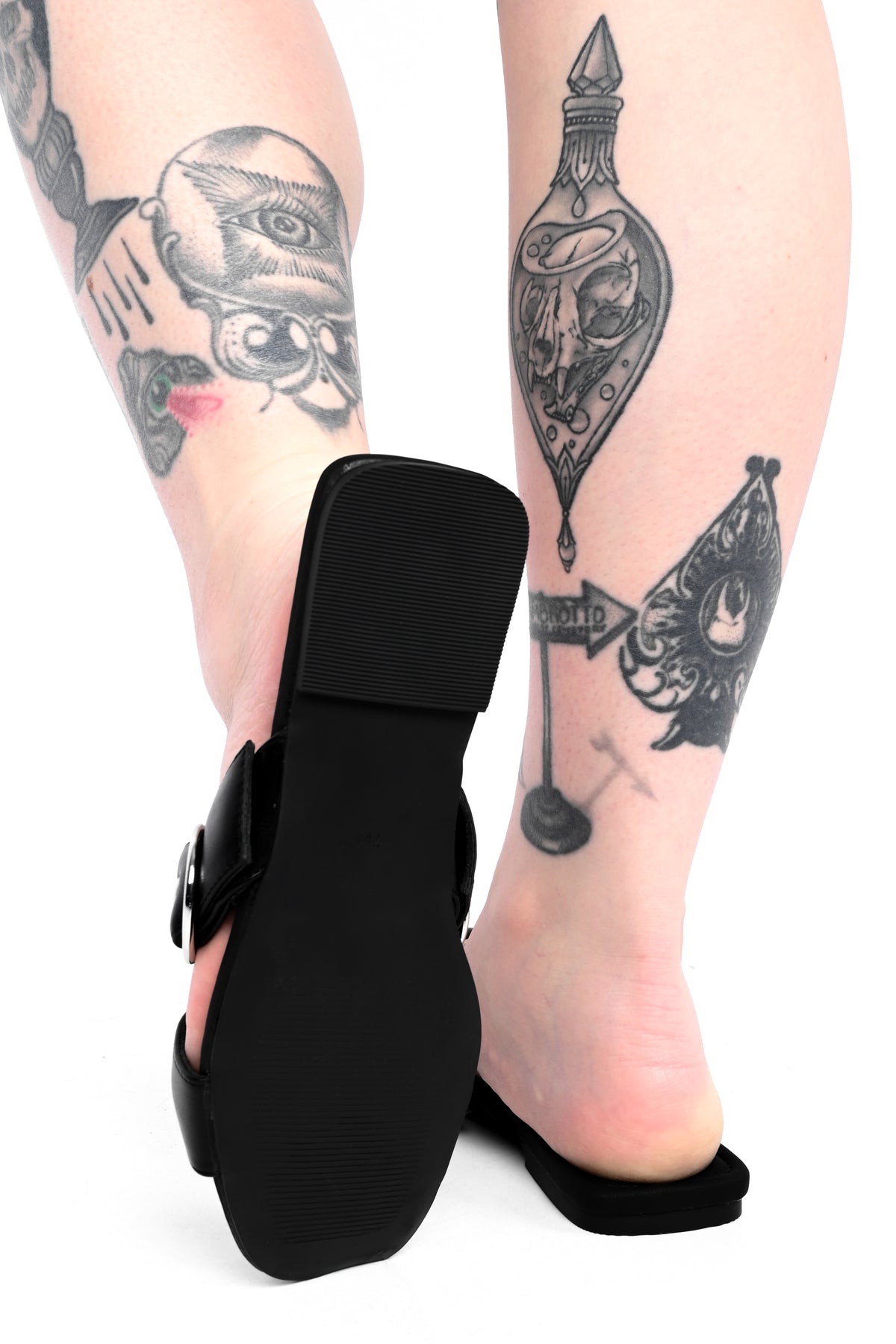 Black slide sandals with o-rings on top and adjustable buckles.