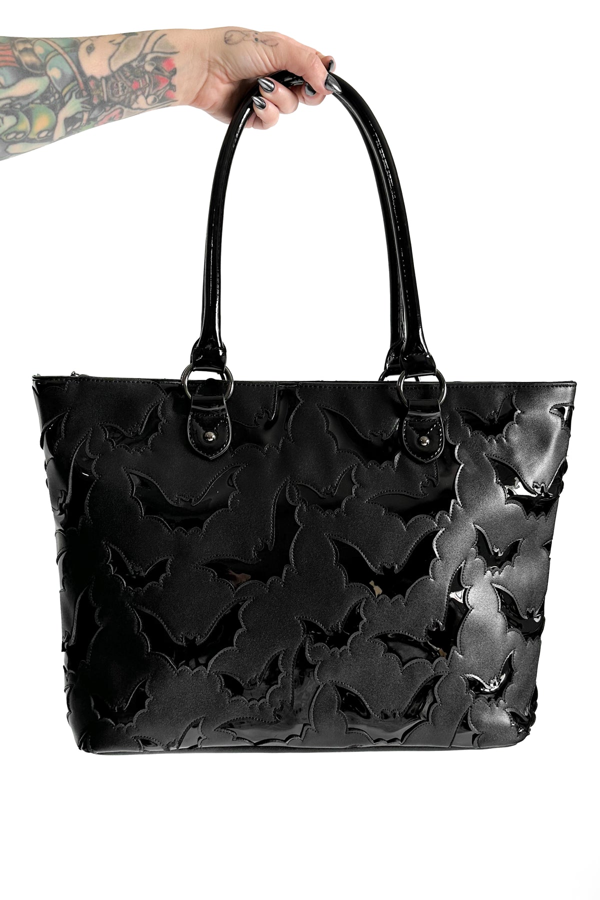 black faux leather tote bag with black patent bats pattern underlay