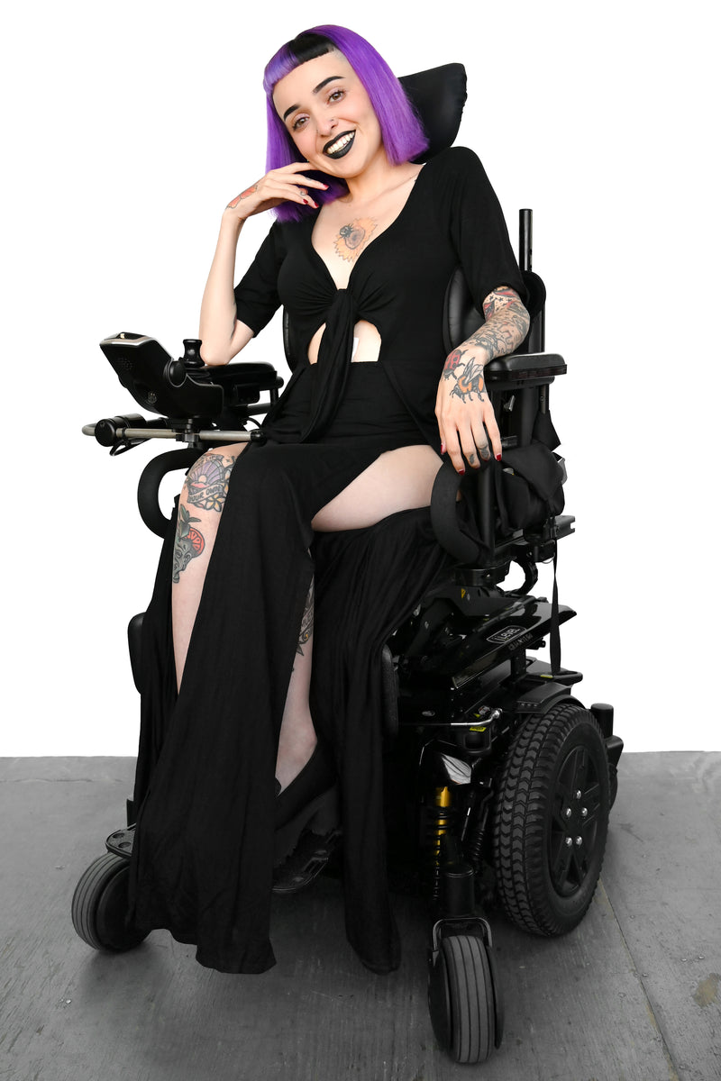 Fitted short sleeve dress with adjustable tie center front detail. Long skirt bottom with two sky high slits in the front. Shown here on a seated model