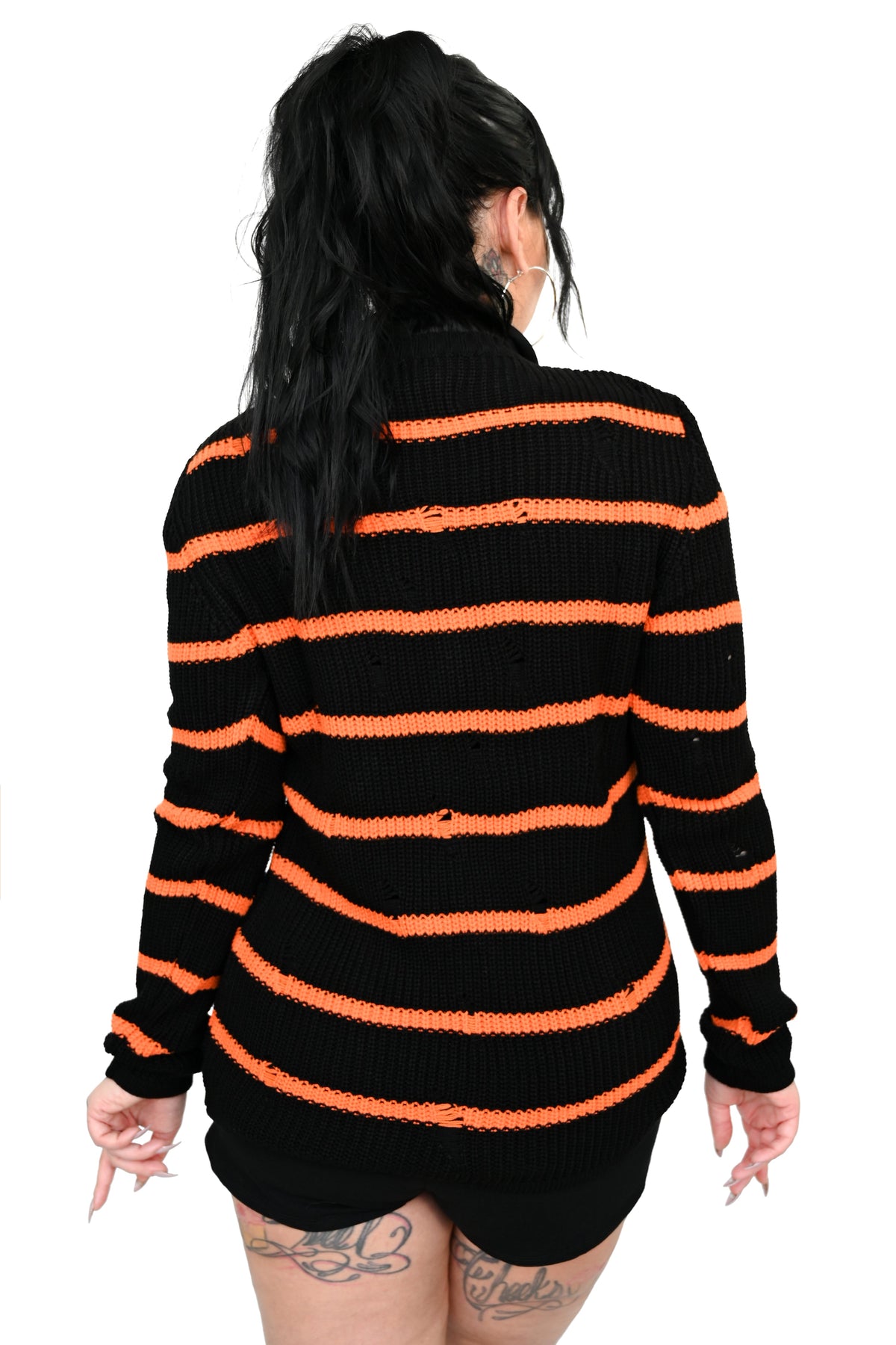 Shredded black sweater with orange stripes. 