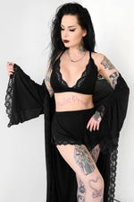 black triangle bralette with lace trim and black shorts with lace trim and a lace trim robe overtop