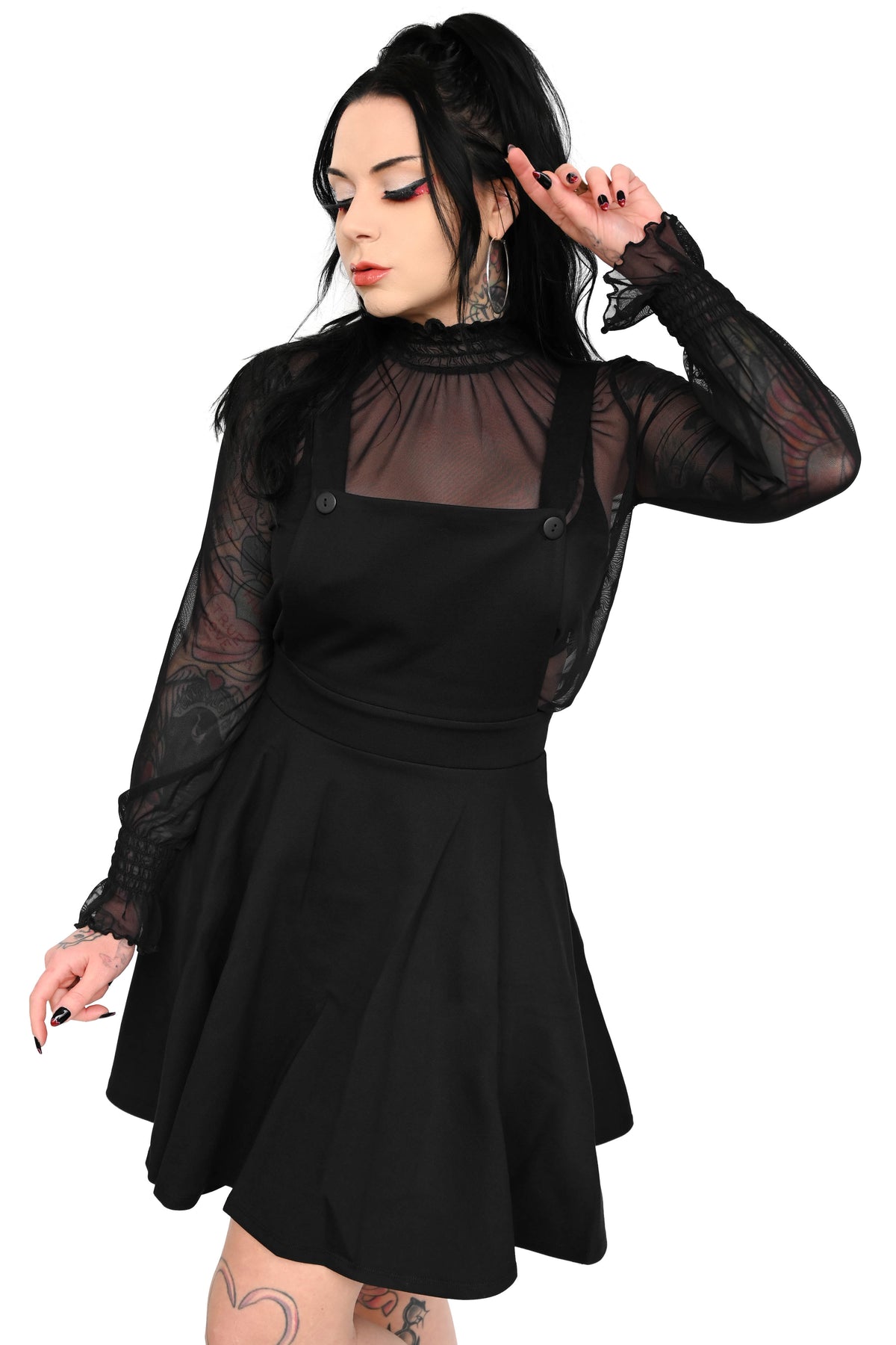 black pinafore short dress layered with a long sleeve mesh top (sold separately) 